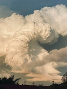 a large cloud is in the sky above some houses