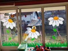 the window is decorated with paper flowers and bees on them, along with other decorations