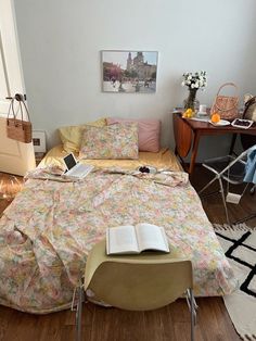 a living room with a couch, chair and book on the floor in front of it