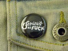 a button that says feminist as fock on the back of a pair of jeans