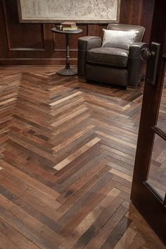 a living room with wood floors and a chair in the corner next to a table