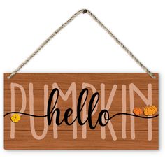 a wooden sign with the word pumpkin hanging from a rope and two small pumpkins on it