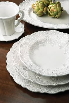 a table topped with white plates and cups