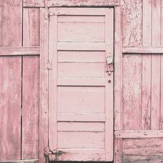 an old door is open in front of some wooden walls and doors that have been painted pink