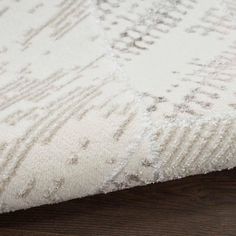 a close up view of a white rug on a wooden floor