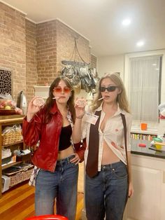 two women standing next to each other in a kitchen