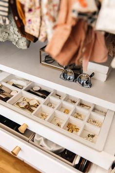 the drawer is filled with jewelry and other items