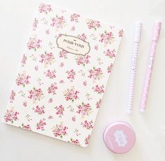 a notebook, pen and eraser sitting on top of a white table next to it