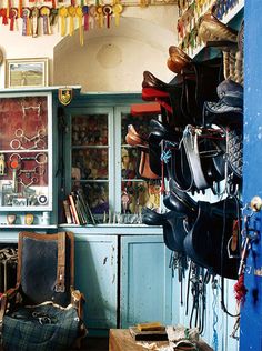 a room filled with lots of different types of shoes and purses hanging from the ceiling