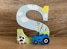 a wooden letter s with a tractor and farm animals