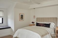 a bedroom with white walls and wood floors