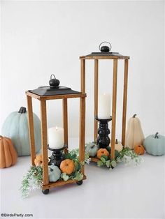 two wooden lanterns with candles and pumpkins on them