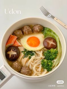 a white bowl filled with meatballs, broccoli and an egg