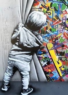 a child standing in front of a wall with graffiti on it's side and back