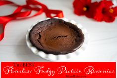 the best chocolate fudge protein bowl is on display with red ribbon and flowers in the background