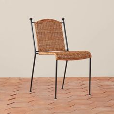 a wicker chair sitting on top of a brick floor