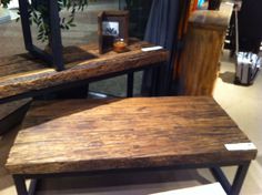 a wooden bench sitting on top of a hard wood floor next to a potted plant