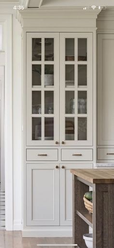 a kitchen with white cabinets and wood floors