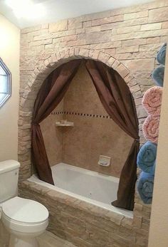 a bath room with a toilet a tub and a mirror on the wall in it