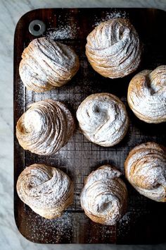 freshly baked pastries on a baking tray with powdered sugar