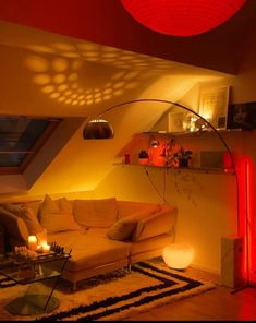 a living room filled with furniture under a red light fixture and lots of lights on the ceiling