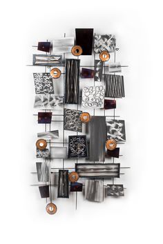 an abstract metal sculpture with many different shapes and sizes on it's sides, hanging from the wall