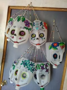 three sugar skulls hanging from hooks on a wall