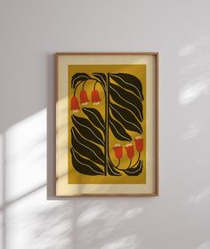 a framed art piece hanging on the wall next to a window with sunlight streaming through it