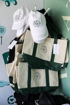 several bags and hats are stacked on top of each other in front of a wall