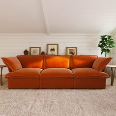 an orange couch sitting in the middle of a living room