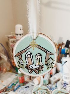 a christmas ornament hanging on a table with other items in the back ground