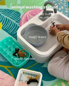 a child is playing with toys and water in a bathtub that has animals on it