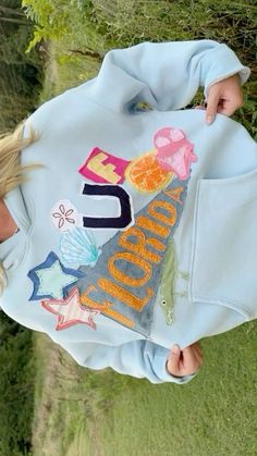 a woman wearing a blue hoodie with an eiffel tower design on it