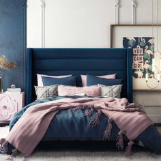 a bedroom with blue and pink bedding, white rugs and pictures on the wall