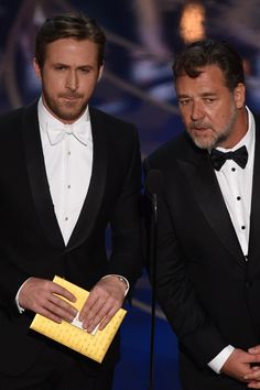 two men in tuxedos standing next to each other at an awards event with microphones