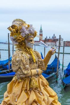 a costumed woman standing in front of some gondolas