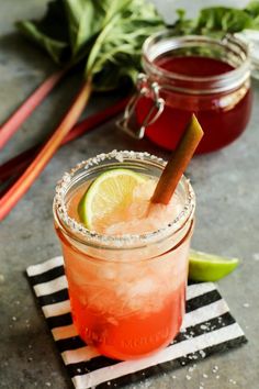 two cocktails sitting on top of a black and white napkin next to each other