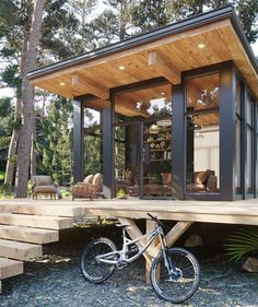 a bike is parked on top of a wooden platform in front of a small house