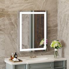 a bathroom vanity with a large mirror above it and flowers in vases on the counter