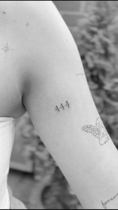 a woman's arm with the word ma on it and a small butterfly tattoo