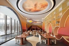 the interior of a restaurant with colorful walls and ceiling murals on the wall, along with wooden tables and benches