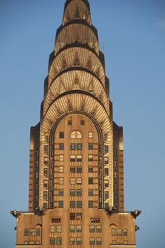 a very tall building with a clock on it's face in front of a blue sky