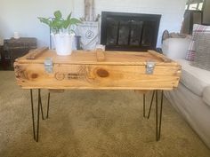 a wooden table with hairpin legs in front of a couch and fire place behind it