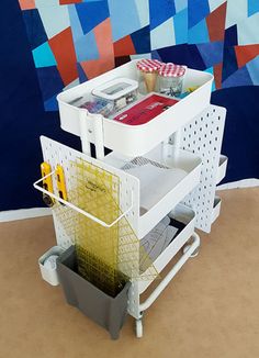 a white cart filled with lots of items on top of a table