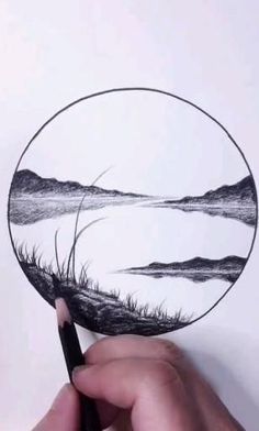 someone is drawing a landscape on a paper