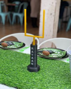 a table set up with plates, cups and footballs on it for a game