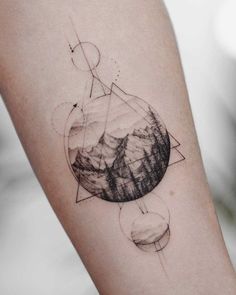 a tattoo on the arm of a person with mountains in the background and an arrow