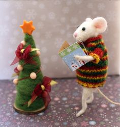 two small christmas trees are next to one another, and the other is a toy mouse