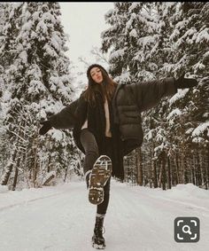 a woman riding a snowboard down a snow covered road