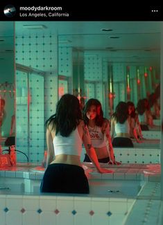 two women are standing in front of a mirror